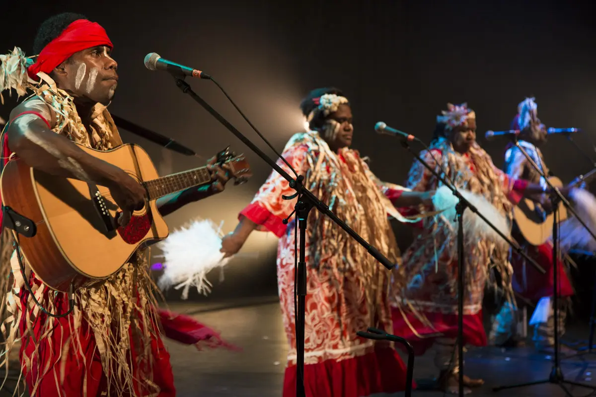 Photo de quatre musiciens calédoniens sur scène dans des tenues traditionnelles
