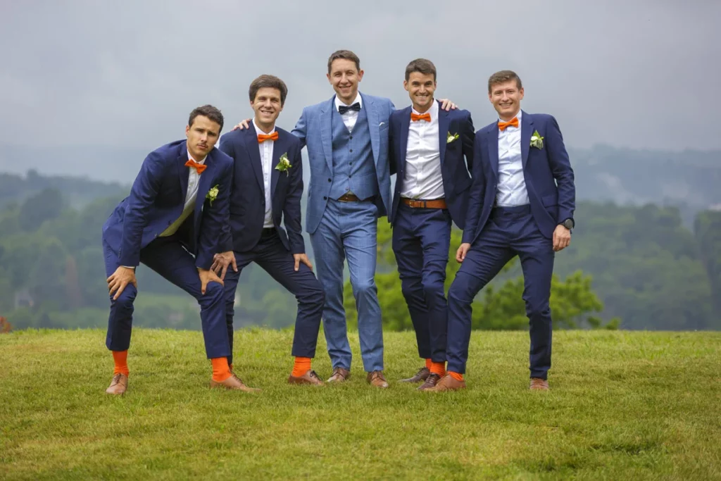 Photo de groupe avec au centre le marié. Les invités portent un nœud papillon orange assortis à leurs chaussettes