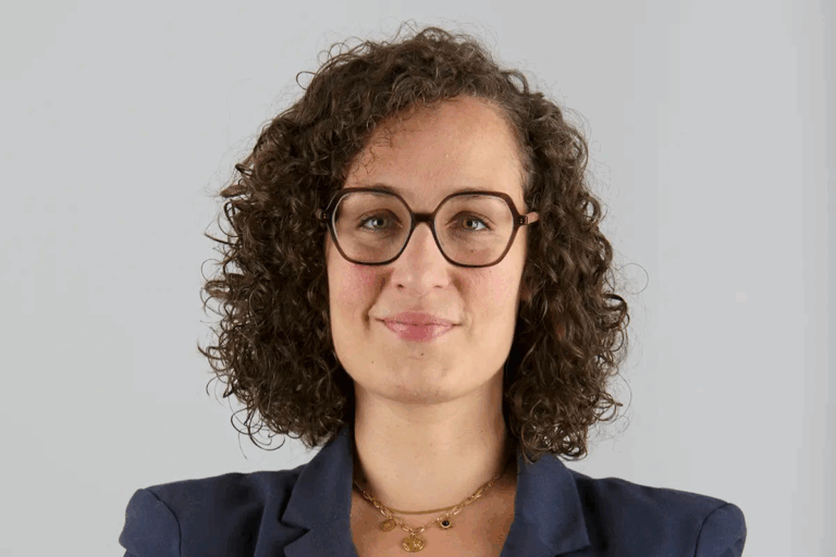 Portrait professionnel d'une femme aux cheveux bouclés portant des lunettes