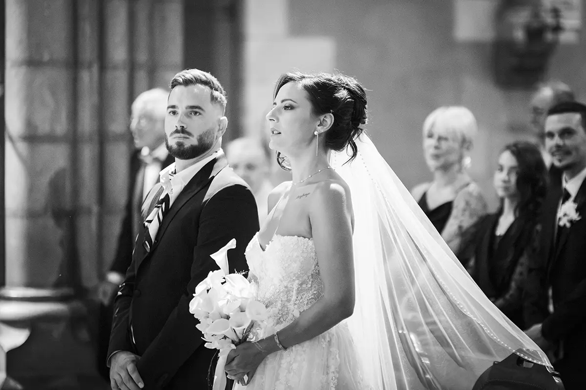 Photo en noir et blanc des mariés concentrés durant la cérémonie à l'église de Pau